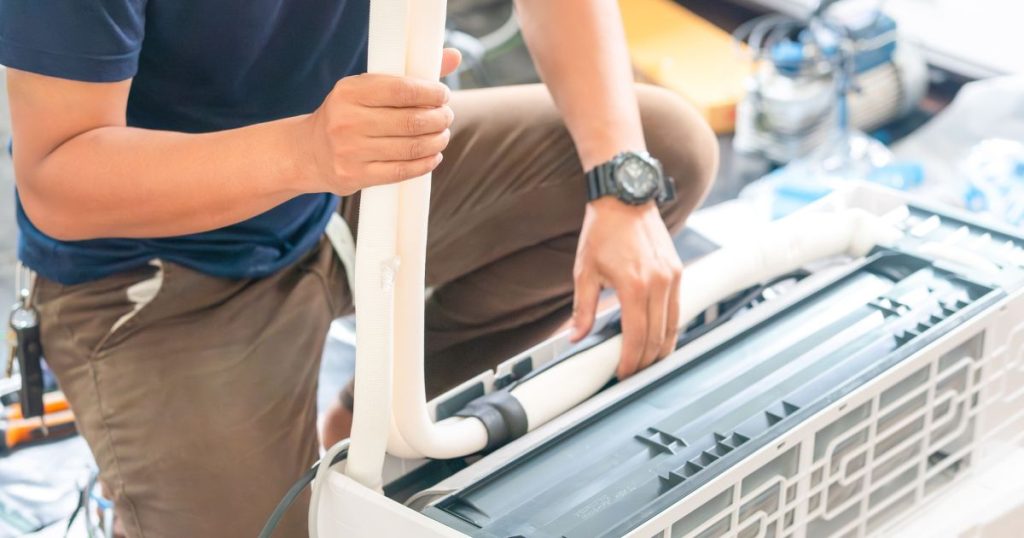 Airco installateur herstelt de koelvloeistofleidingen van een vaste airco binnenunit