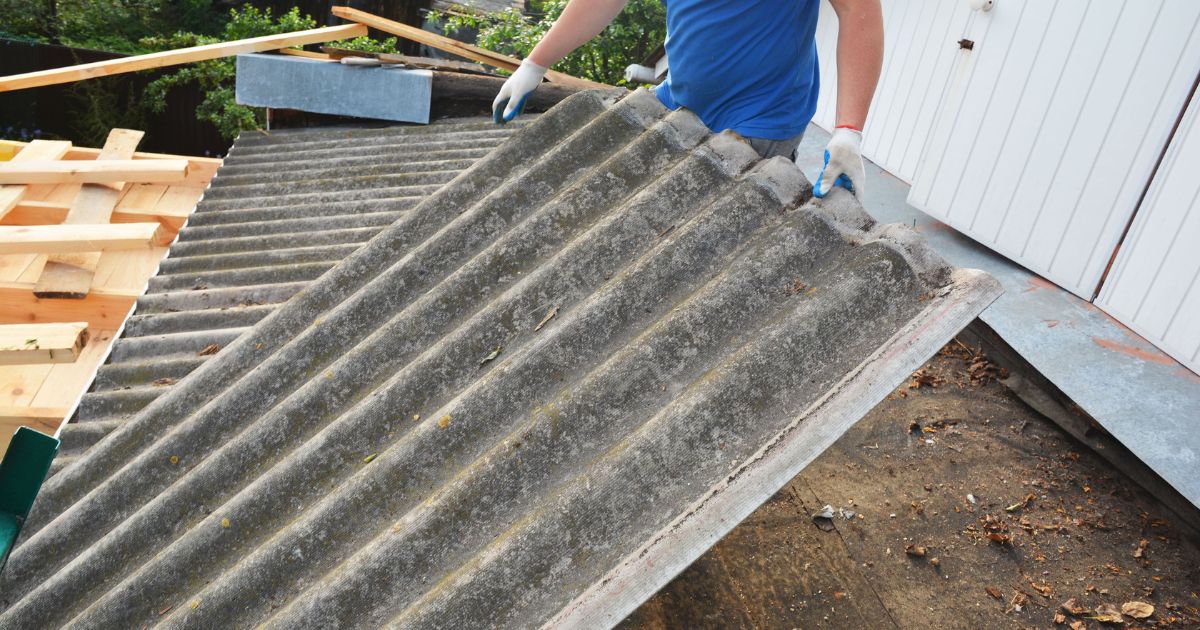 Asbest golfplaten worden verwijderd van een dak.