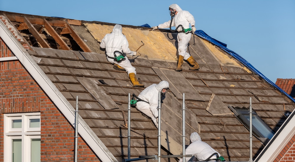 Zowel de platen als de onderliggende isolatie worden verwijderd door gespecialiseerde vakmannen in witte beschermingspakken. Ze dragen ook een masker tegen eventueel vrijkomend asbest tijdens de opruimingswerken.
