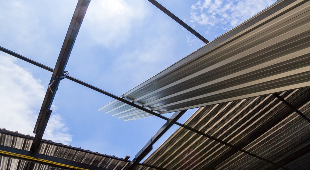 Een golfplaat staat klaar om op een metalen structuur of dakgebinte geplaatst te worden.