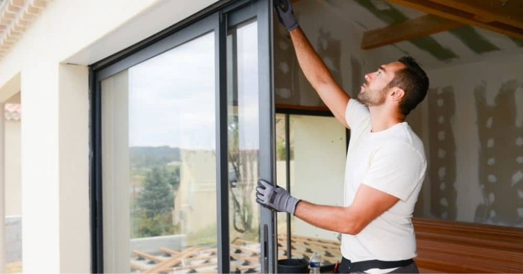 Een vakman die isolatieglas installeert.