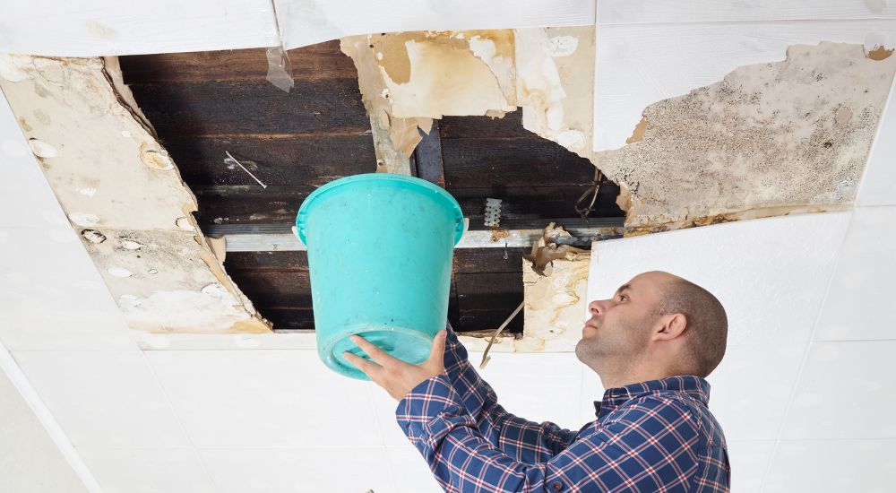 Proberen het water van een lek aan een plafond op te vangen.