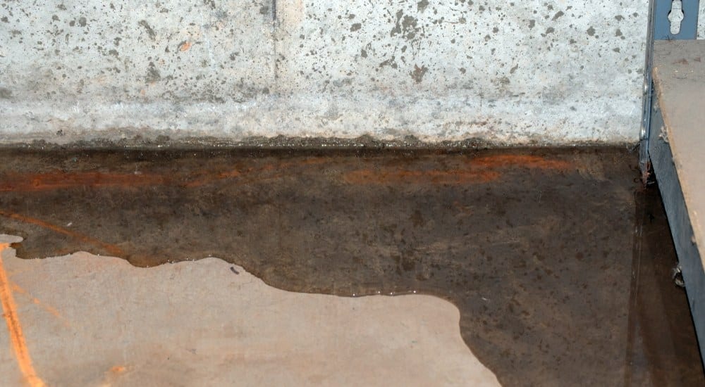 water in kelder. Er is een natte roestige keldervloer te zien