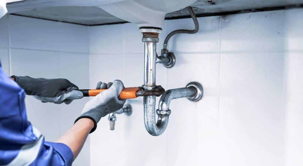 Afvoerbuis herstellen onder een wasbak om een lek te voorkomen.