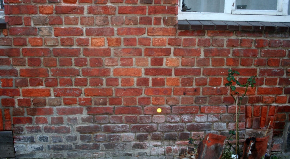Opstijgend vocht witte uitslag op de buitenkant van een woning. 