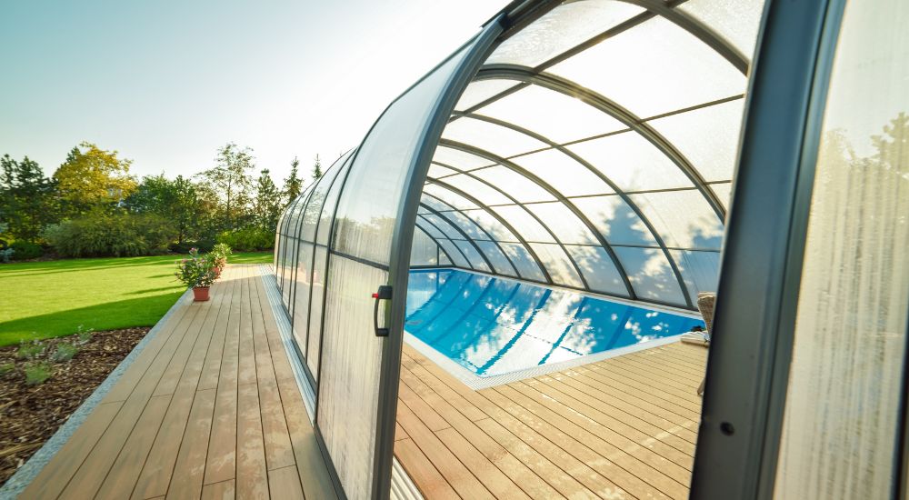 Een openlucht zwembad met uitschuifbare overkapping in transparante pvc.