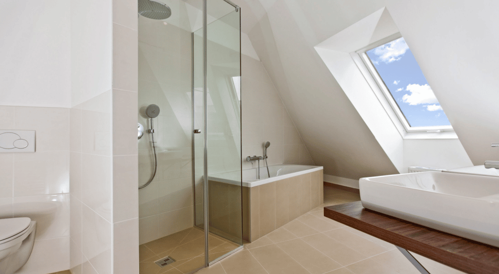 Badkamer onder schuin dak met een douche.