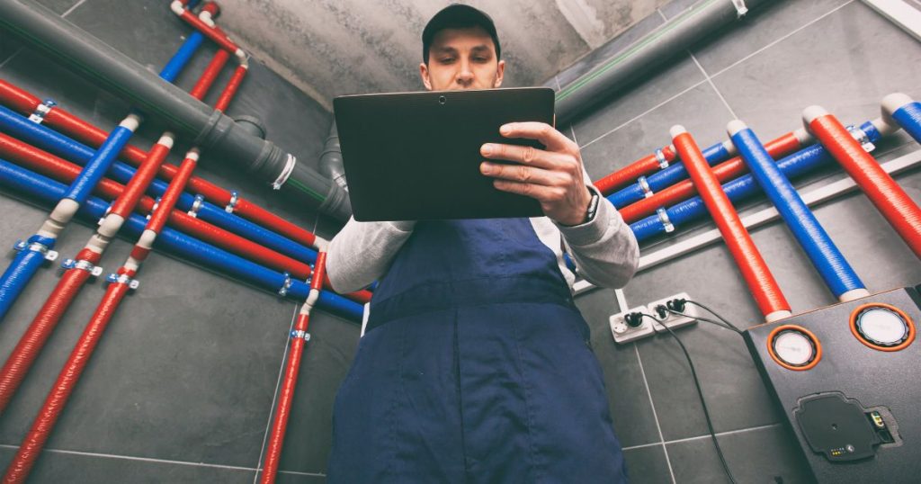 Een monteur controleert de configuratie van een Remeha warmtepompboiler.