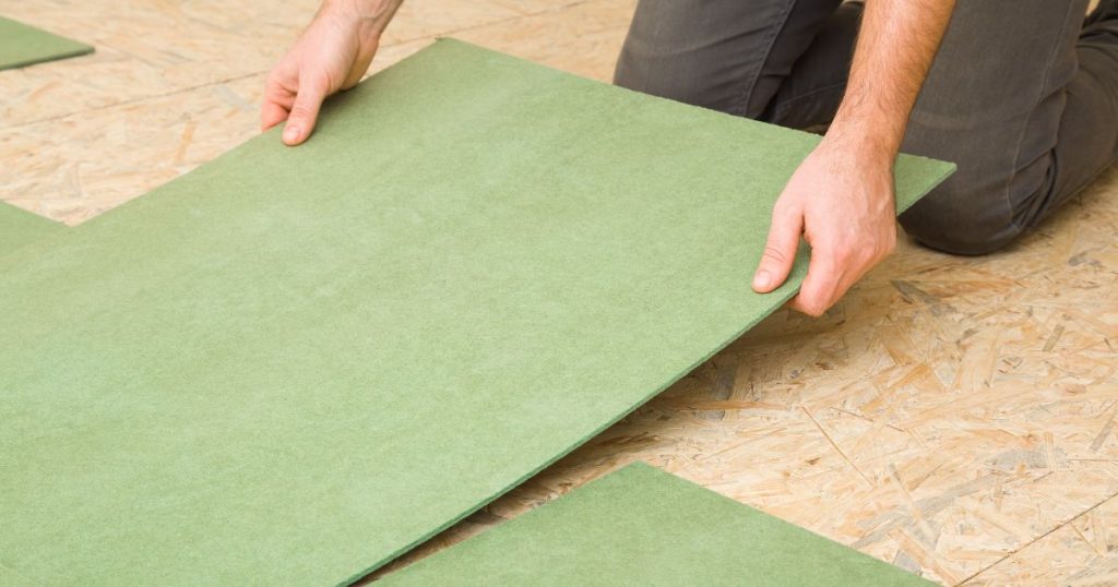 Een man is de vloer van een veranda aan het isoleren.