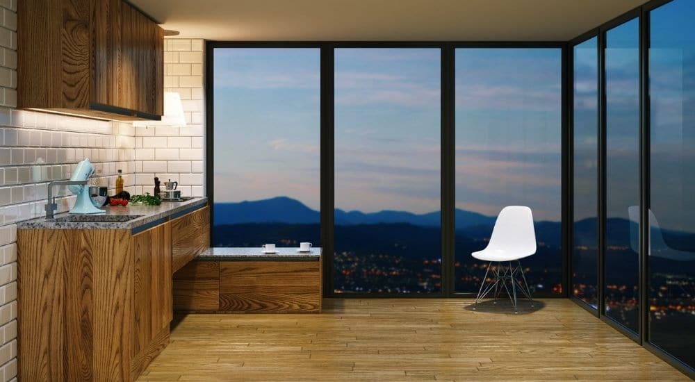 Grote ramen met stalen profielen: via de ruiten heb je uitzicht op de stad en op de bergen in de achtergrond.