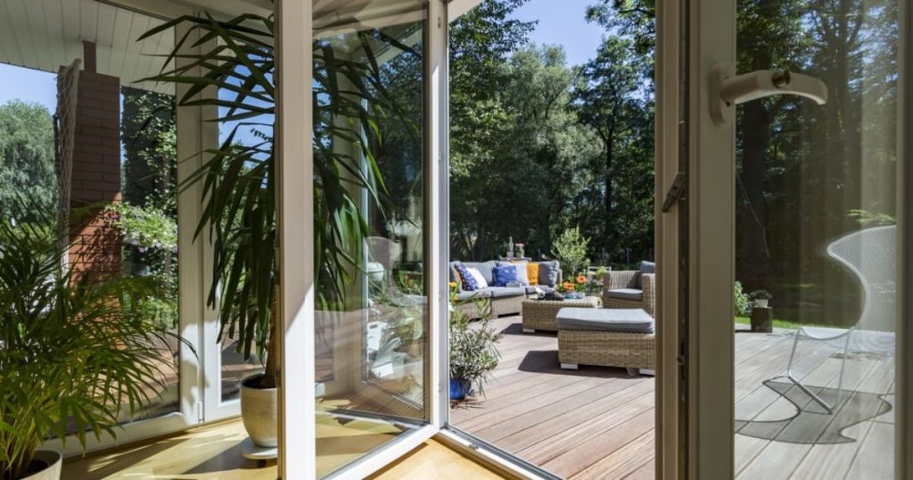 pvc serre met openslaande deuren naar een terras buiten.