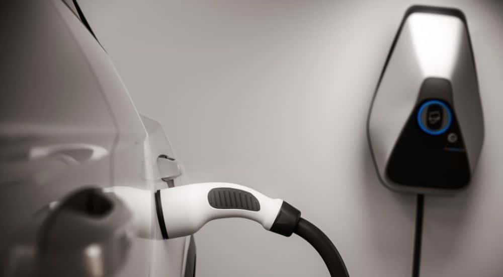 Een eerste stap in hoe een laadpaal werkt: een elektrische auto die met een laadkabel is verbonden aan een laadpunt.