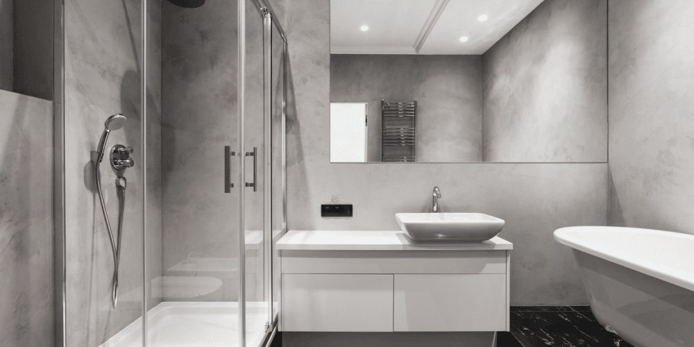 Doorzichtige douchewand kunststof in grijze badkamer.