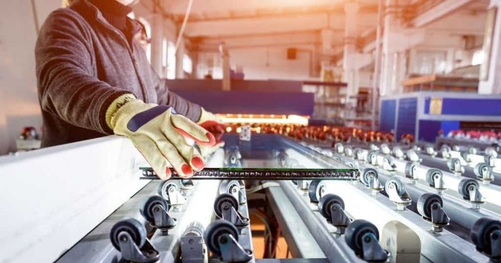 Een werkman die werkt aan gewapend glas.