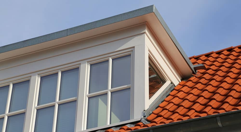 Dakkapel op een woning met dakpannen.