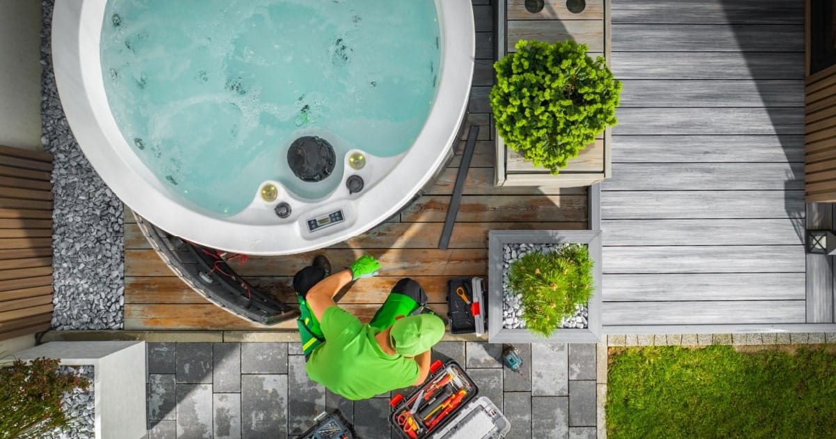 Een installateur controleert een jacuzzi warmtepomp.