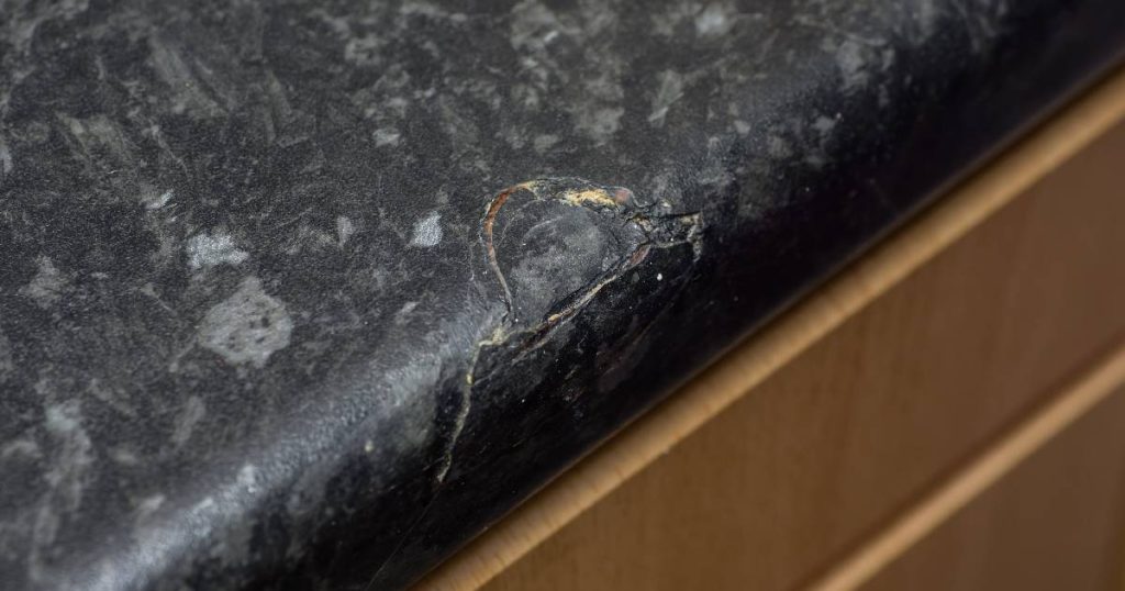 Een natuurstenen keukenblad met schade dat nood heeft aan renoveren.