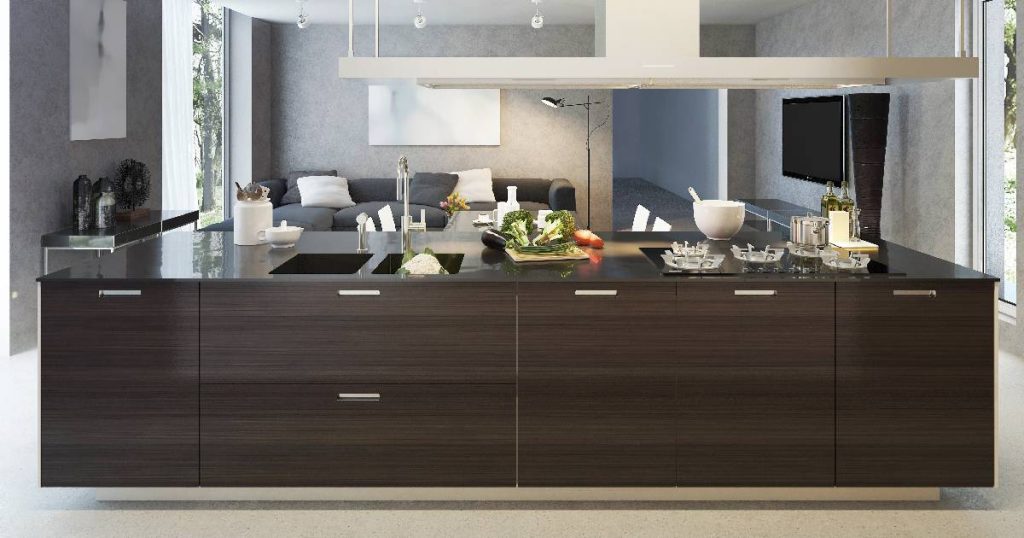 Een volledige keuken in een keukeneiland met spoelbak, kookplaat en afzuigkap.