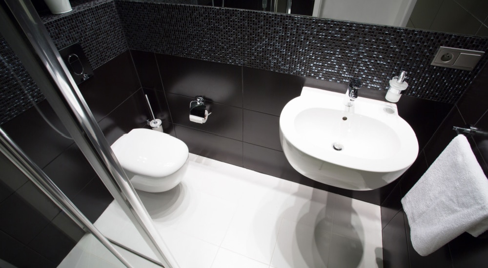 Zwevend toilet in zwarte badkamer.