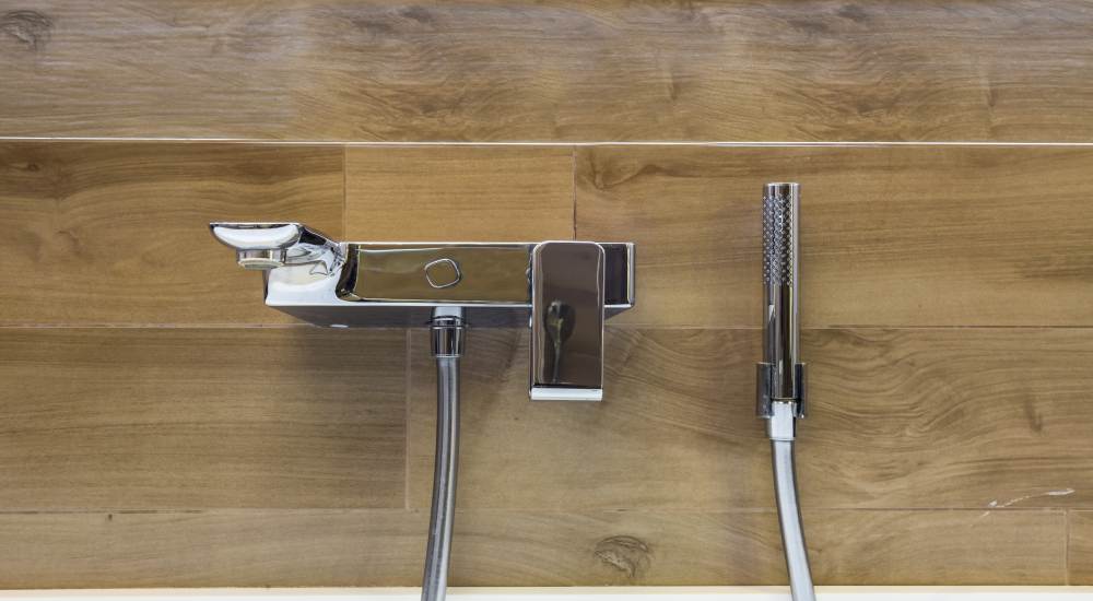 Badkraan met hout als achtergrond.