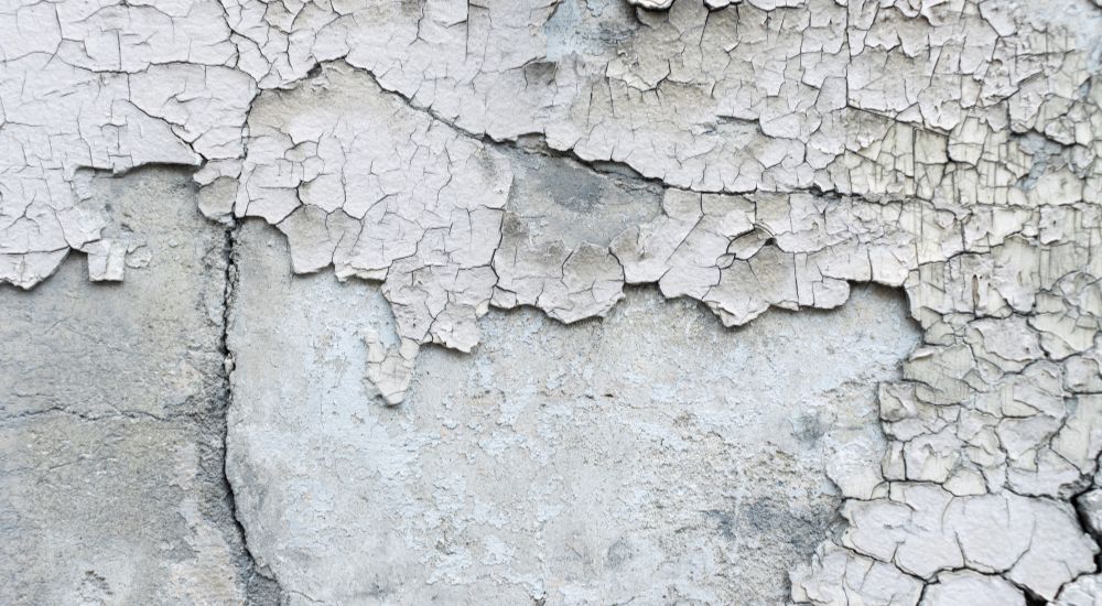 Een buitenmuur breekt af door veel vochtschade