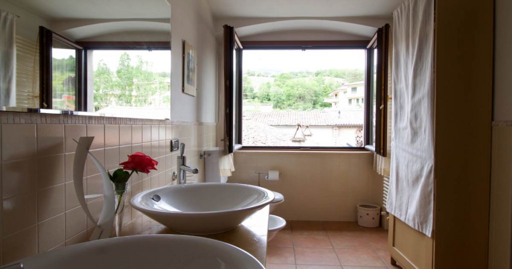 Een badkamer waarin de ruimte wordt geventileerd door middel van een open raam, er is geen andere afvoer voor ventilatie aanwezig.