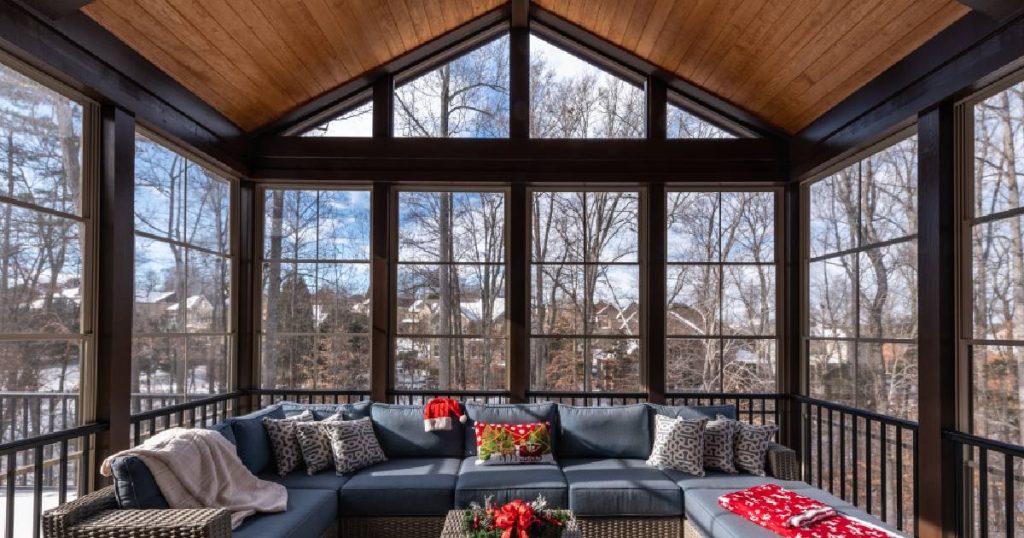 Een houten veranda met grote glazen ramen en puntdak die moeilijk te isoleren valt.