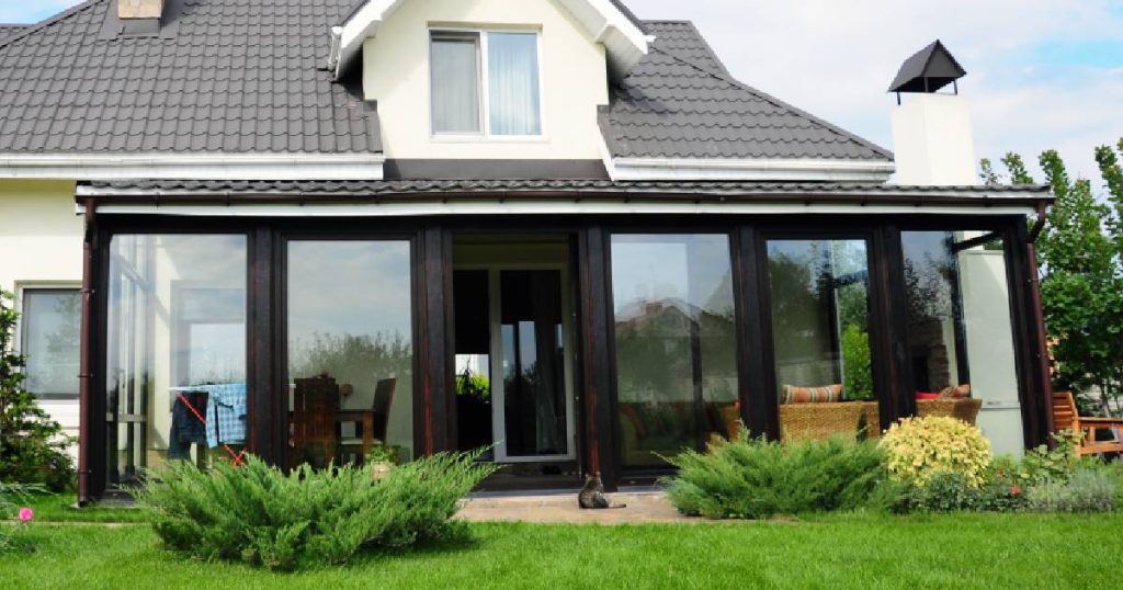 Een moderne serre met grote ramen en zwart, aluminium frame.