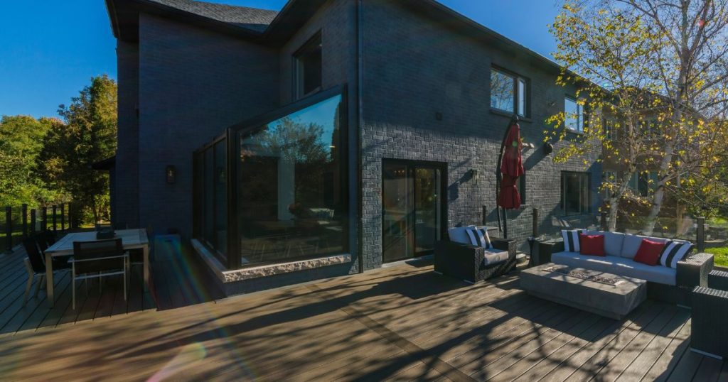 Kleine glazen serre aan een huis waar geen vergunning voor nodig is. De serre grenst aan de tuin en een terras.