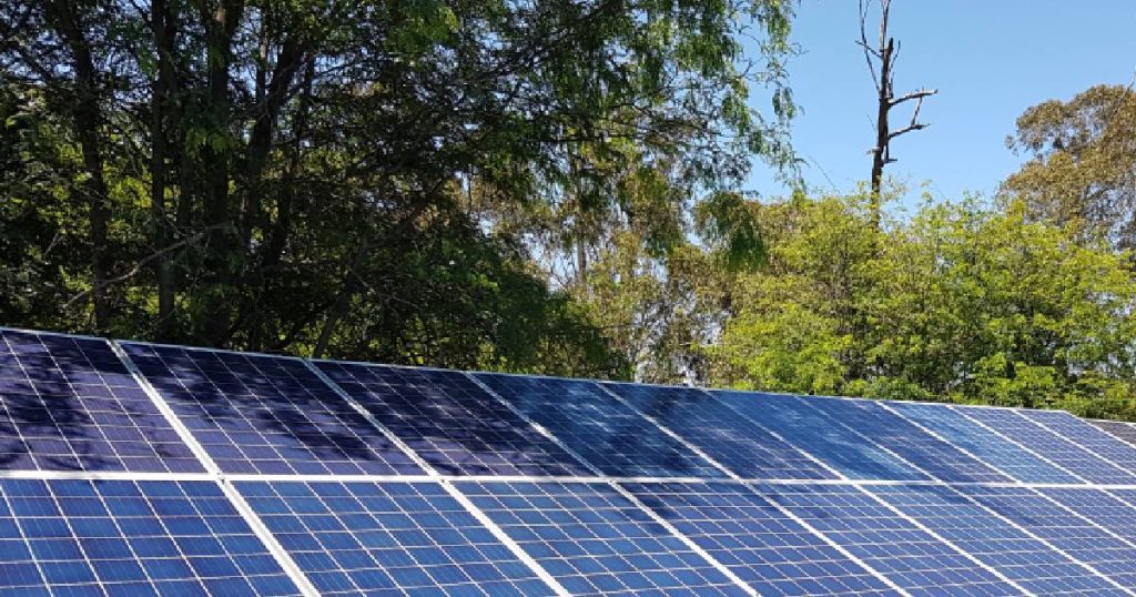 Een installatie met zonnepanelen waarop schaduw valt: het gaat om gedeeltelijke schaduw of diffuus licht, zonlicht dat deels geblokkeerd wordt door gebladerte.