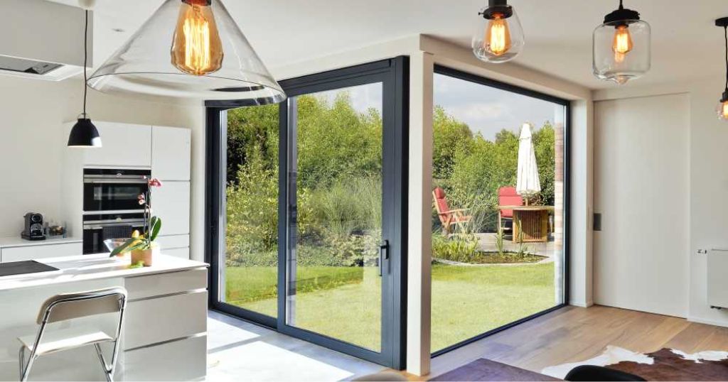 Aluminium schuifraam in een keuken met uitzicht op een tuin.