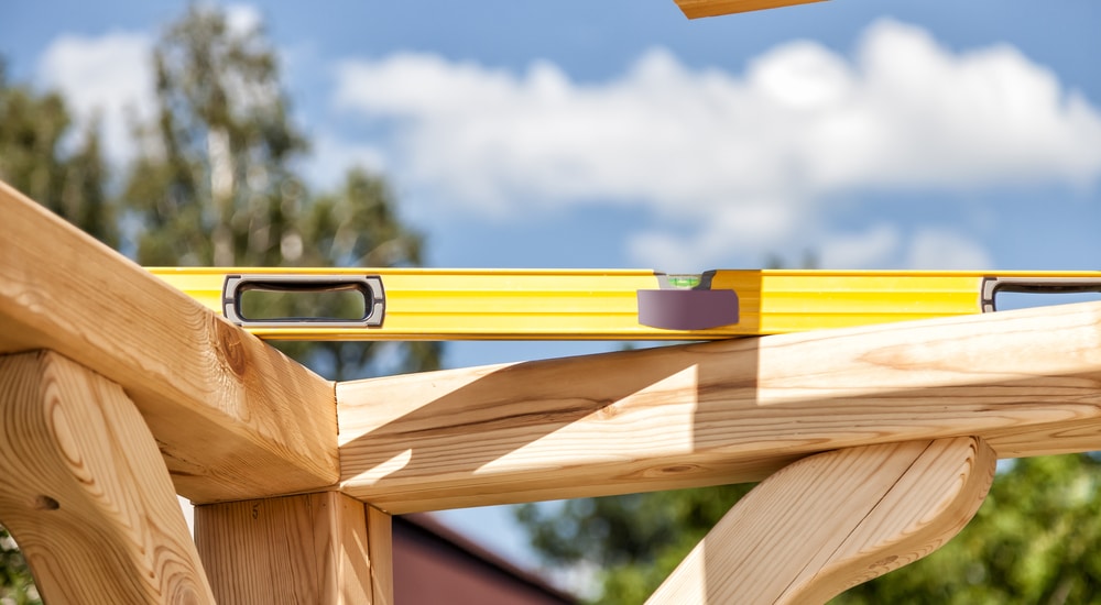 Een houten carport in opbouw met waterpas