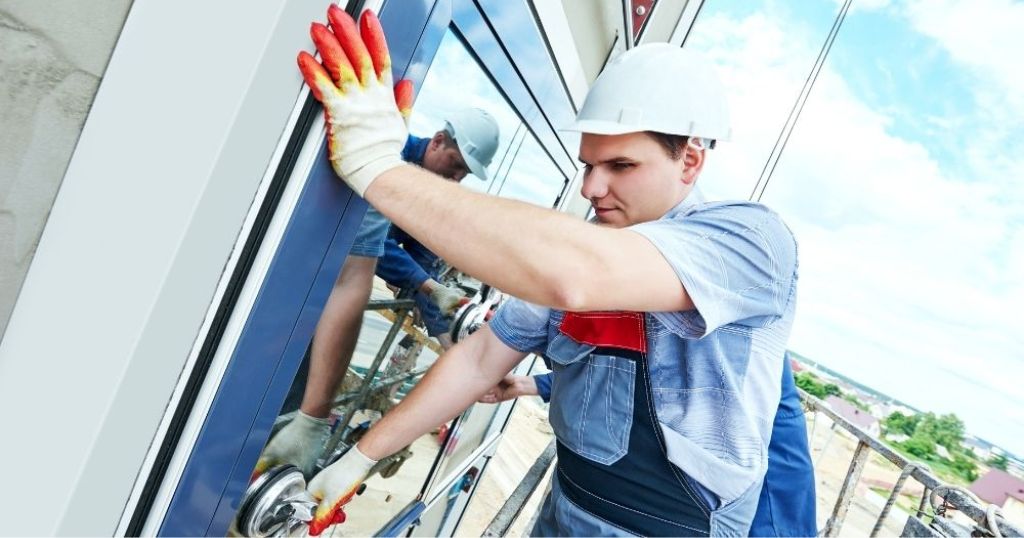 Een vakman die een raam plaatst