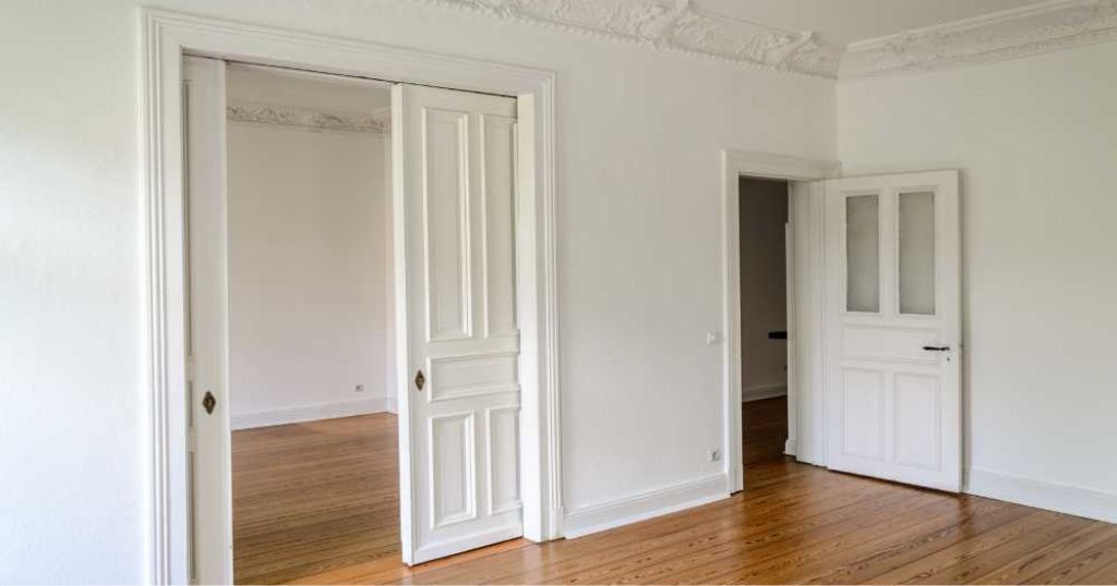 Houten schuifdeuren in wand in een witte lege kamer.