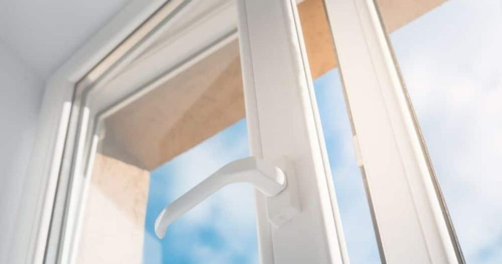 Een wit raam met kunststof kozijnen. 