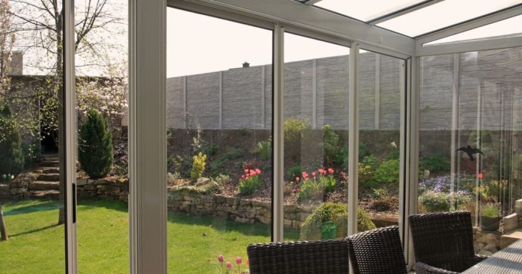 Een schuifpui bij een veranda met uitzicht op de tuin. 