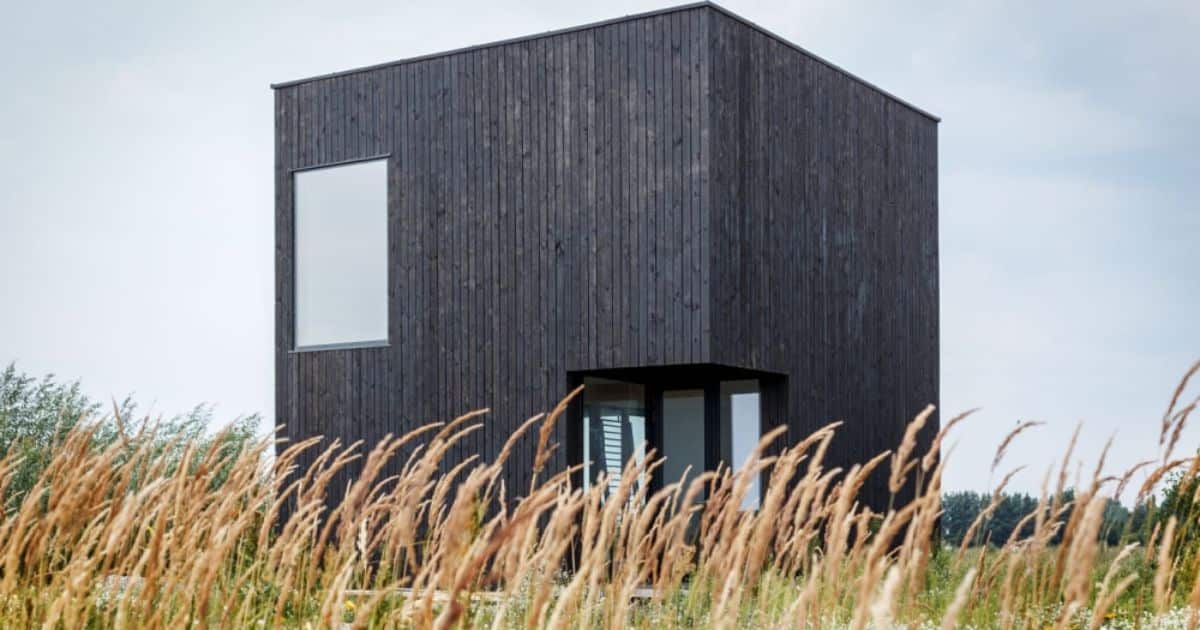 Moderne kubusvormige woning met zwarte gevelbekleding in gebrand hout