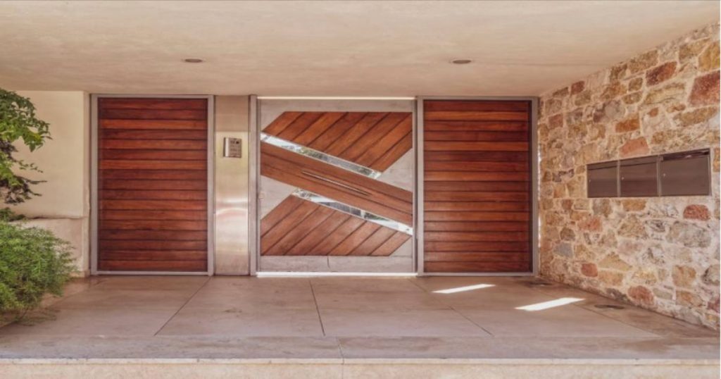 Een huis heeft een poort met afrormosia gevelbekleding, die is geplaatst met balken.