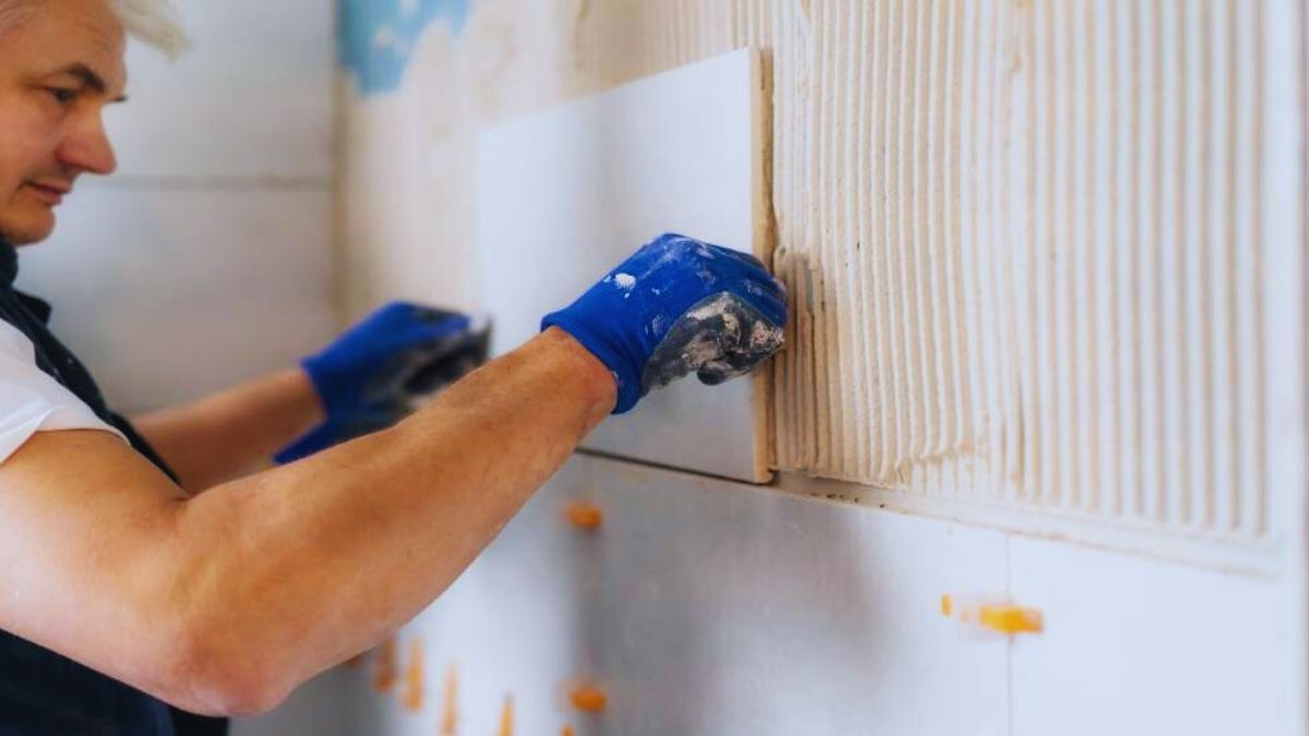 Tegelzetter bezig in de badkamer.