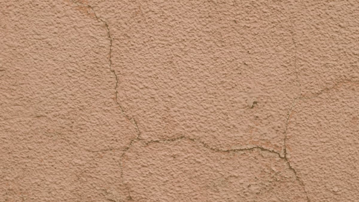 Meerdere krimpscheuren zijn zichtbaar in de gevel van een woning. 