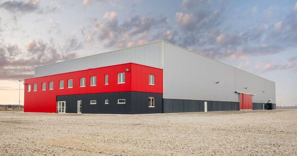 Modern bedrijfsgebouw met PVC-gevelbekleding in rood, grijs en zwart.