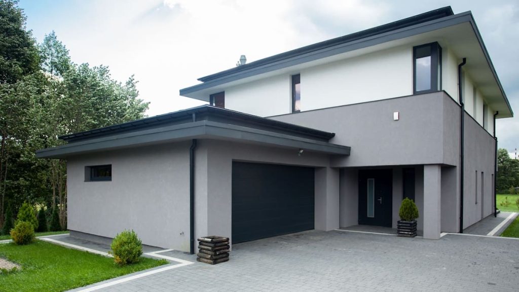 Een woning waarvan een gedeelte van de sierpleister grijs is gekleurd en een ander gedeelte is wit gekleurd.