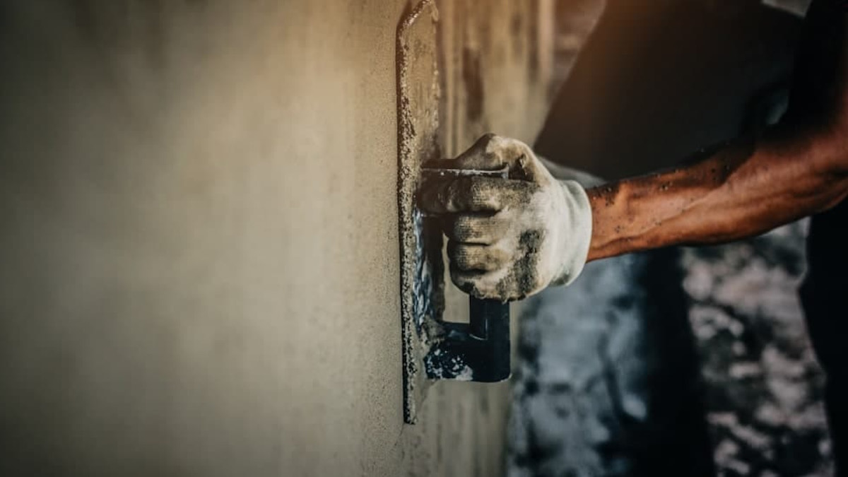 Een stukadoor stuct een gevel. 