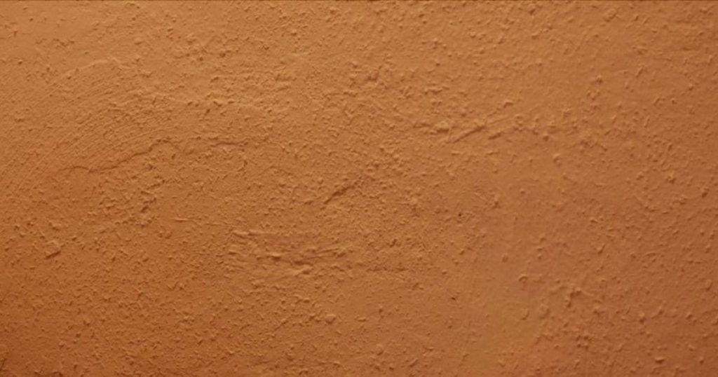 Een warm bruine kleur buitenmuur met cementpleister