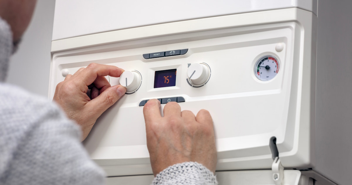 Een cv-ketel wordt ingesteld. Tussen de verschillende knoppen is een display met een temperatuur zichtbaar