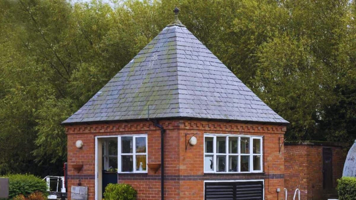 Vooraanzicht van een bakstenen woning met puntdak: een eigenwijze dakconstructie voor hellende daken.