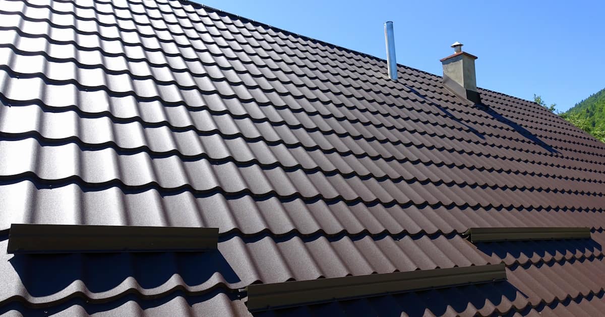Een dak met strakke, bruine dakpanplaten als dakbedekking