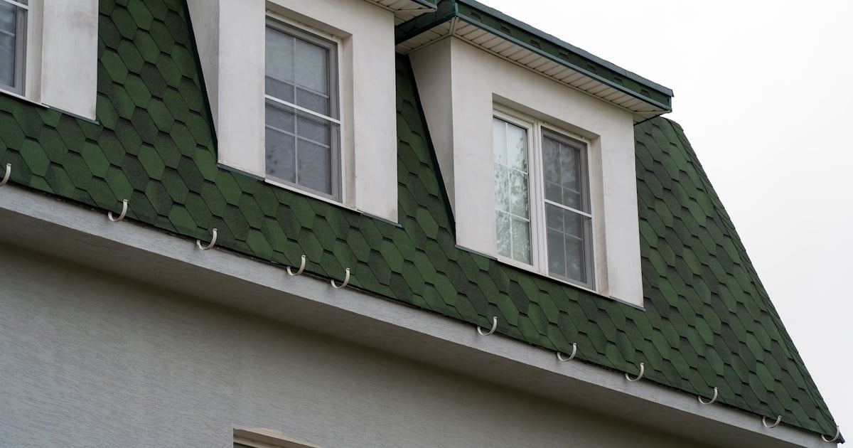 Een dak met groene, hexagonale dakshingles. De zeshoekige vorm geeft een interessante uitstraling