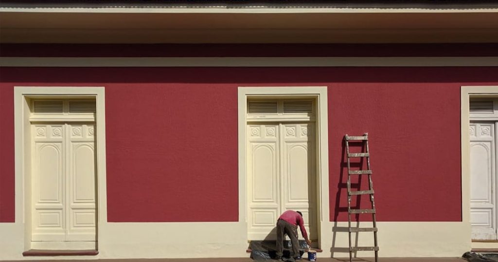 Een opvallende rode gevelkleur wordt gecombineerd met beige deuren en kozijnen. 