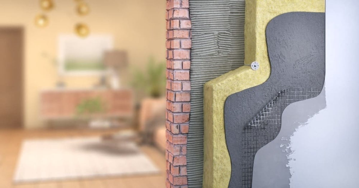 Een doorsnede van een geïsoleerde muur. We zien een binnenmuur, isolatielaag, wapeningslaag en een afwerkingslaag.